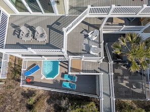 Vista aérea de un resort con varios niveles de terraza, zonas de estar al aire libre y una piscina.