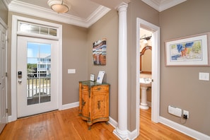 Classic entryway with a wooden door, glass panel, and a small cabinet with a marble top.