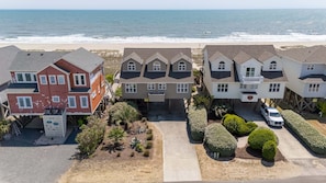 Una zona residenziale sul lungomare, con case, una spiaggia sabbiosa e l'oceano.