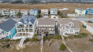 Un quartier résidentiel situé sur la côte, composé de nombreuses maisons à deux étages dotées de balcons et offrant une vue sur le littoral.