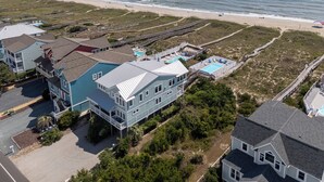 A coastal residential area with houses, a beach, and a boardwalk.