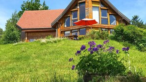 A wooden house with a red roof, large windows, and a red umbrella. - Nid de la Bergeronnette - The entire Chalet (Dabo)