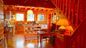A wooden cabin interior with a kitchen, dining area, and a staircase. - Nid de la Bergeronnette - The entire Chalet (Dabo)