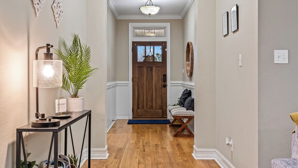 A hallway with a wooden floor, a bench, a lamp, and a door. - Manassas House 4 BDR  Patio Firepit (Tallahassee)