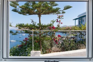 Une vue sur la côte, avec un arbre, des fleurs et des bateaux.