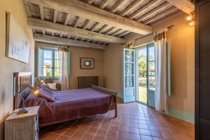 A bedroom with a bed, bedside table, lamp, and a view of the outside. - Hotel Apartment "Olivo" with Shared Pool & Wi-Fi (Trequanda)