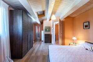 A bedroom with a bed, a nightstand, a lamp, a wardrobe, and a hallway leading to other rooms. - Apartment In A Hotel "Villa Pesca" with Shared Pool, Private Balcony & Wi-Fi (Trequanda)