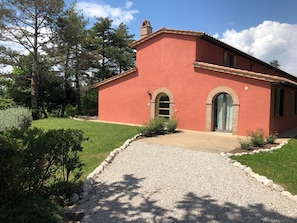 A red building with a gravel driveway, arched windows, and a brick chimney. - Apartment In A Hotel "Villa Cielo" with Shared Pool, Private Terrace & Wi-Fi (Trequanda)