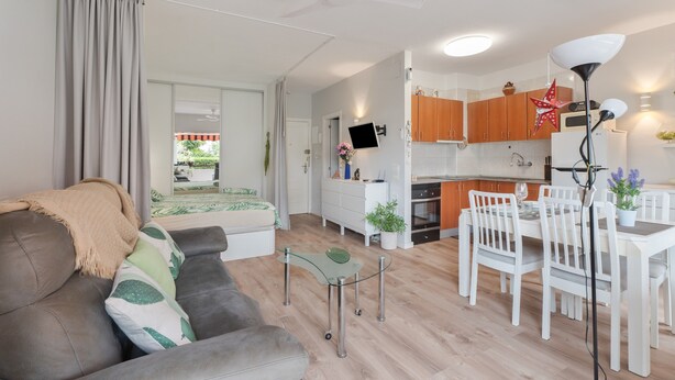 Un apartamento moderno con sala de estar, comedor, cocina y un balcón.