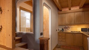 Un intérieur en bois comprenant un espace cuisine, avec des placards, un four à micro-ondes et une cuisinière.