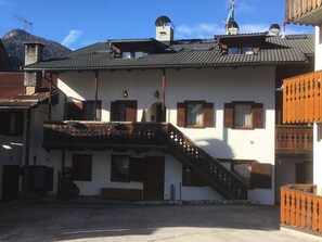 Ein traditionelles Gebäude mit Balkon, Treppe und Schornstein.