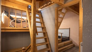 Un escalier en bois menant à un balcon d’où l’on peut admirer la mer.