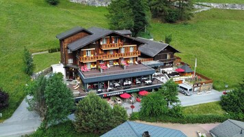 Un hotel de estilo chalet con balcón y zona de estar al aire libre.