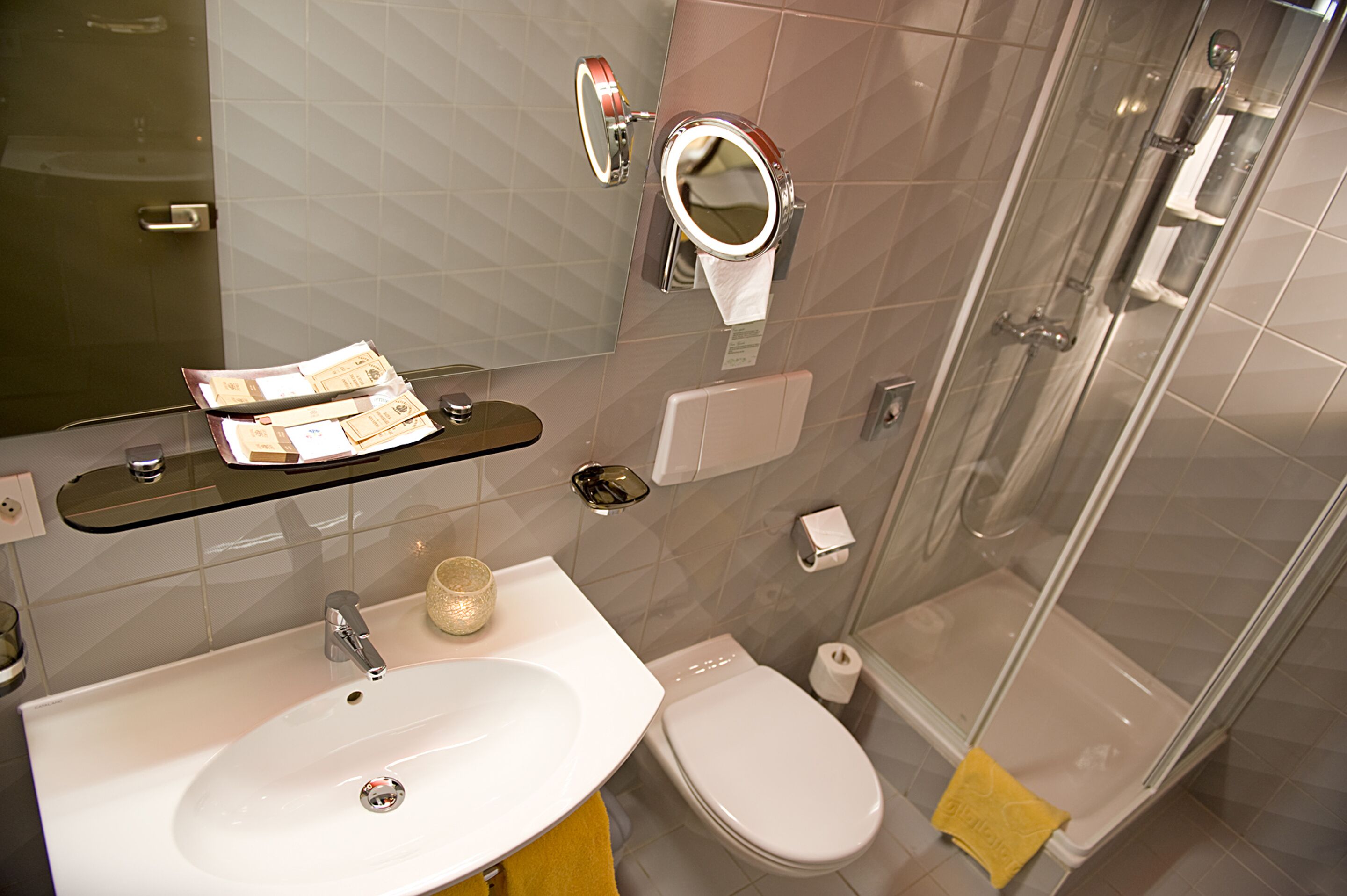 Een moderne badkamer met een wastafel, toilet en douche.