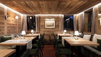 Un restaurant aux murs en bois, avec de nombreuses tables et des chaises.