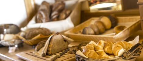A variety of breads and pastries on a wooden counter.