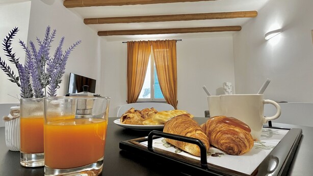 Ein Frühstückswagen mit Croissants, einer Tasse und zwei Gläser Orangensaft.