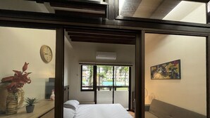 Una camera da letto con un letto, una finestra, un quadro e una sveglia appesa al muro.