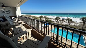 A balcony with a view of a beach, a pool, and lounge chairs. - "Newly remodeled Breakers East 303" Gulf front 3BR/ 2BA Beach setup included (Destin)