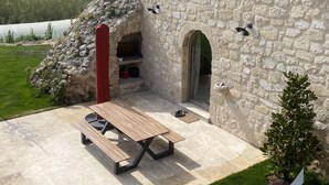 A stone building with a wooden bench and a red pillar.