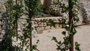 A stone building with a rustic exterior, featuring a small window and a door.