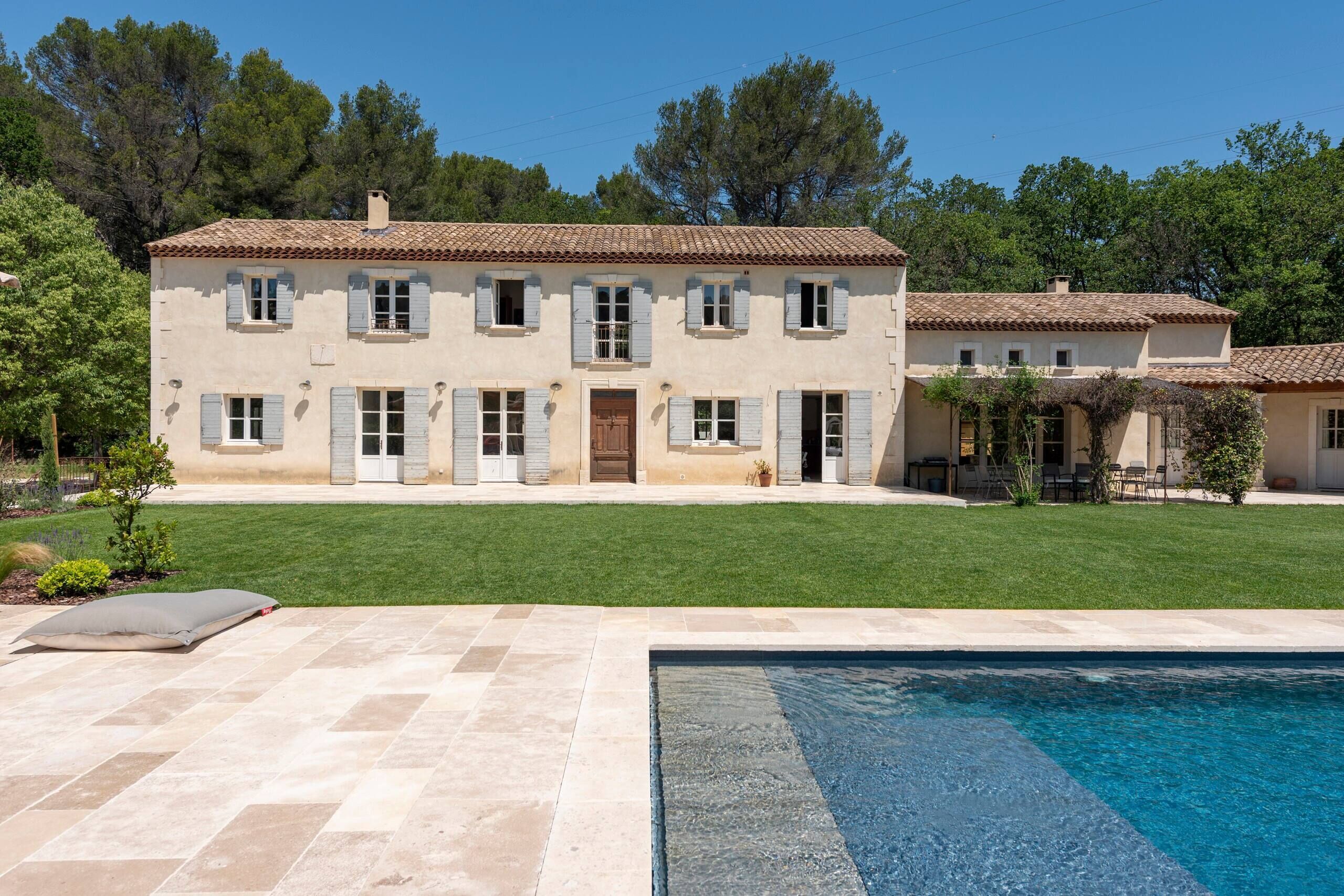 Une maison à deux étages avec une piscine à l’avant.