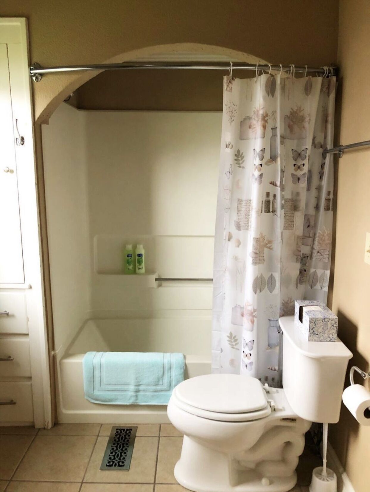 Un baño con ducha, inodoro y un perchero para toallas.