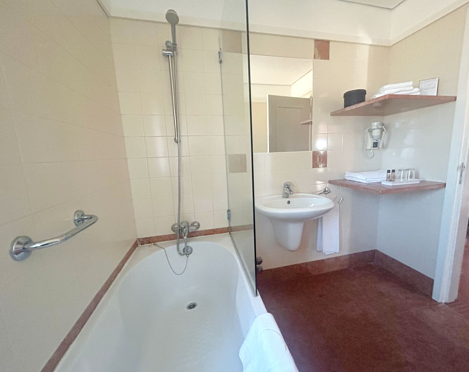 A bathroom with a bathtub, a shower, a sink, and a mirror.