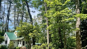 A house with a green roof, surrounded by tall trees and a grassy yard. - 40min from Portland- Sandy Ridge Family Cottage (Oxford)