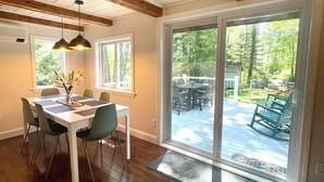 A dining area with a white table, green chairs, and a vase of flowers. - 40min from Portland- Sandy Ridge Family Cottage (Oxford)