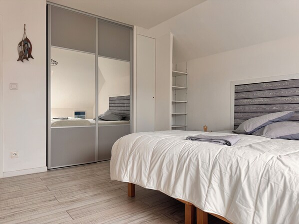 A bedroom with a bed, a wardrobe, and a headboard.