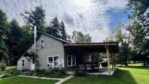 A house with a covered porch, a lawn, and a pathway leading to the entrance. - 4 season Adventures! Waterfront, *Hot tub*<br>Deer River Paradise! (Brasher falls)
