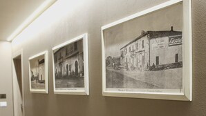 A hallway with framed black and white photographs of buildings. - Hotel Gabbani  (Bibbona)