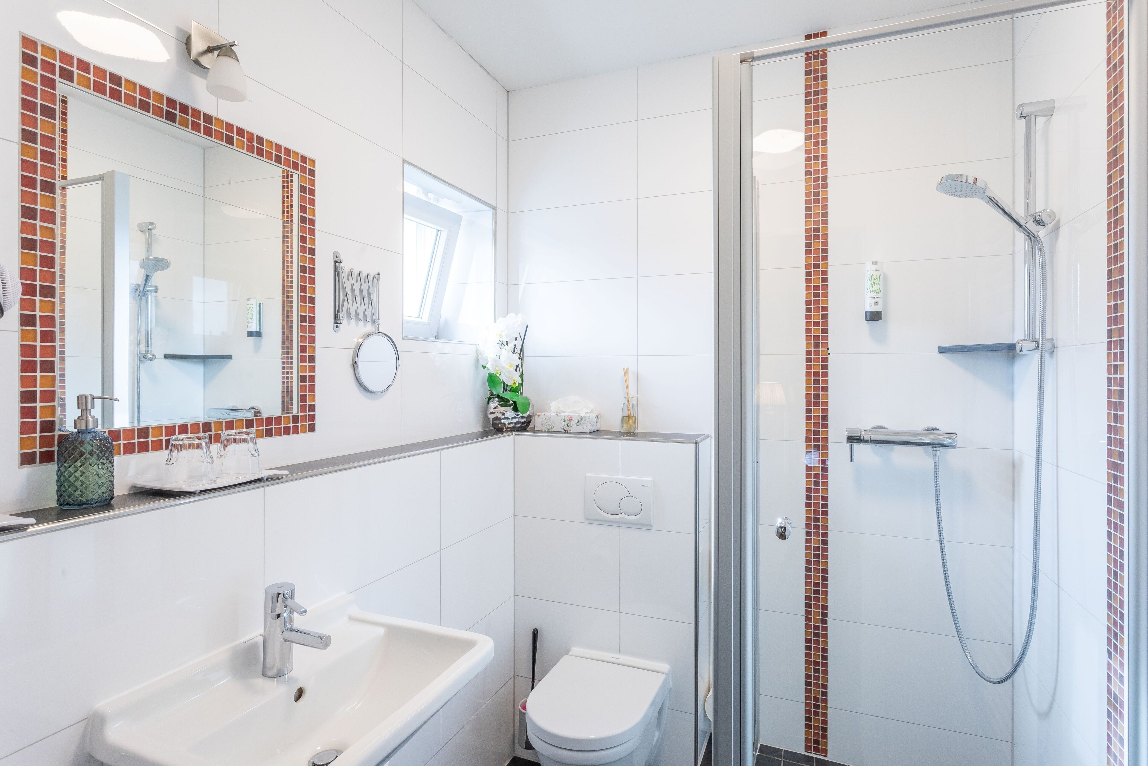 A bathroom with a sink, toilet, and shower.