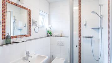A bathroom with a sink, toilet, and shower.