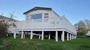 Une maison à deux étages avec un balcon, une façade blanche et un toit plat.