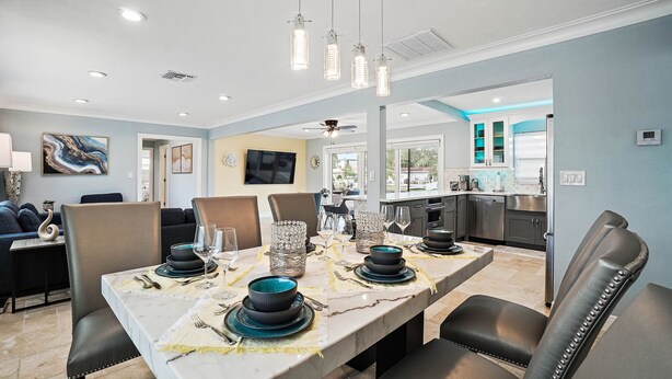 A dining area with a marble table set for six, surrounded by leather chairs.