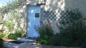 A rustic building with a white door labeled "Les Deux Puits," a small window, and a lattice wall. - Entire Cosy cottage with pool idyllic location close to Aubeterre AMAZING VALUE! (Saint-Romain)