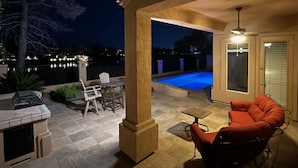 A covered patio area with a pool, outdoor furniture, and a view of the water. - Water/Golf Course Backyard | Heated Pool Included in Price | Modern 3 bedroom (Chandler)