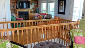 Een gezellige woonkamer met een houten balustrade, een televisie en een open haard.