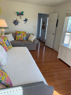 A spacious room with a large bed, a patterned sofa, and a door leading to another room. - Stunning ocean views, private pool (optional heated) and 350 ft. from the beach! (Supply)