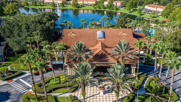 A resort with a central courtyard, palm trees, and a lake in the background.