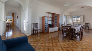 A spacious living area with a dining table, chairs, a sofa, and a TV stand. - 3156 Villa Andrea House by Barbarhouse (Porto Cesareo)