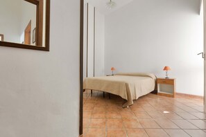 A bedroom with a bed, a nightstand, a lamp, and a mirror. - 2345 Le Due Torri - Torre Grande by Barbarhouse (Melendugno)