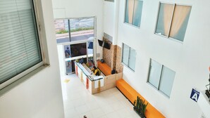 A modern hotel lobby with a reception desk, seating area, and large windows. - Apartment 5 minutes from the Coffee Park, near Panaca, Salento, Cocora. (Montenegro)
