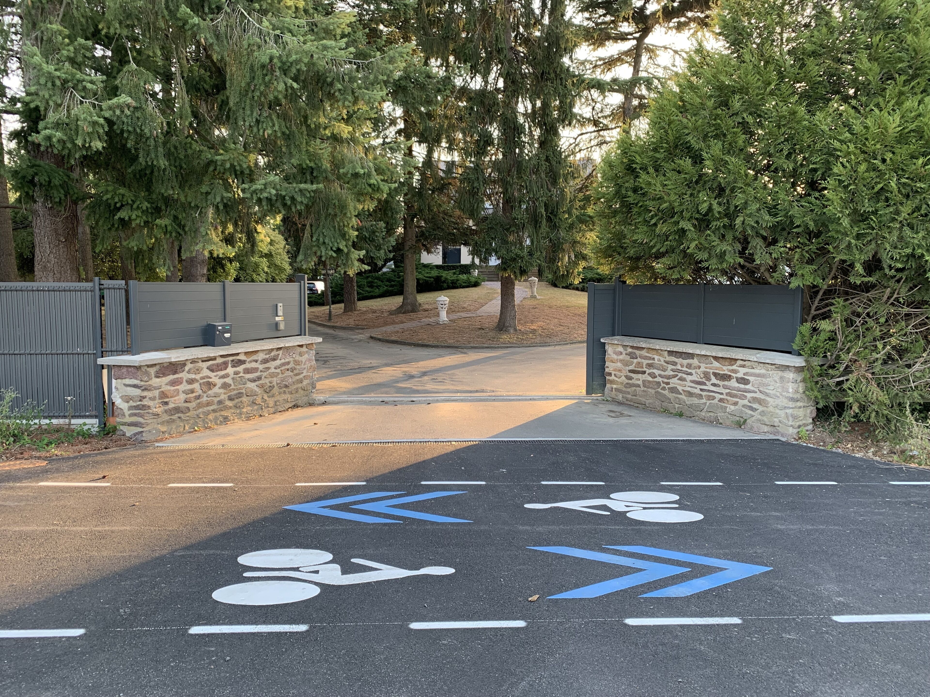 Un camino de entrada con puerta y zona de estacionamiento para bicicletas.
