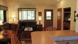 A cozy living room with a dining area, a sofa, a coffee table, and a television. - Beautiful house on Lake Rathbun with in-ground pool & 50-amp camper hookup (Plano)