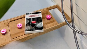 A shower area with a wooden shelf holding candles and a book. - Romantic modern Black Forest loft | Netflix | WiFi | free public transport (Sasbachwalden)