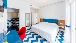 A hotel room with a bed, a red chair, a blue table, and a bathroom visible through an open door. - La Vigna di Bacco (Furore)