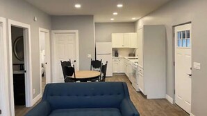 A compact living space with a dining area, kitchenette, and a blue sofa. - Peaceful Escapes and Retreats (Battle Ground)
